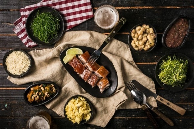 Close up of a table setting with pork and side dishes