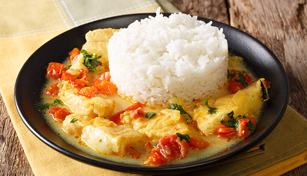  Pescado encocado or fish with coconut sauce close-up on a plate. Horizontal