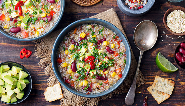 Vegetable quinoa soup, stew with avocado, corn, beans. South American traditional dish