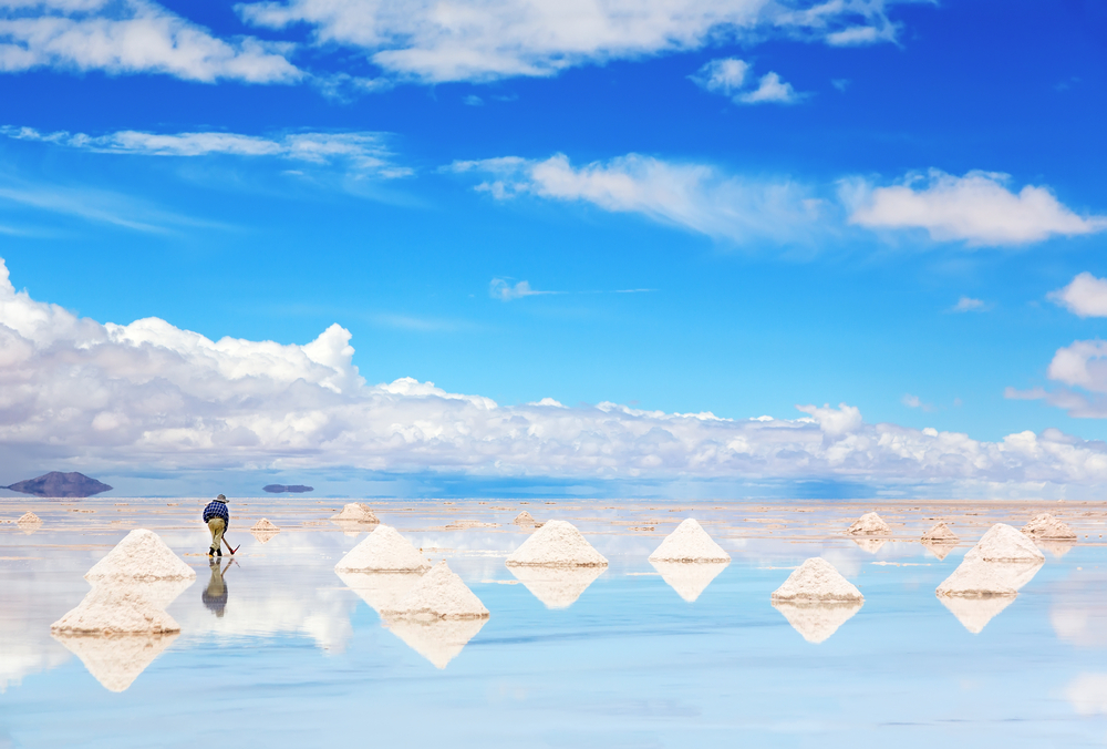 Worker performing harvesting salt on the salt lake Salar de Uyuni. 